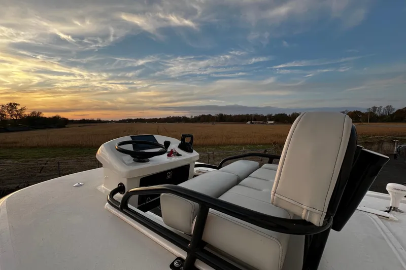 Slide: The Image of 2024 Pair Customs 24DV boat helm with sunset view over fields. - 24