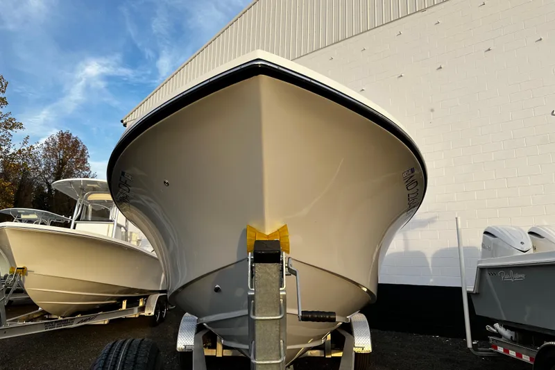 Slide: The Image of 2024 Pair Customs 24DV boat on trailer, parked outdoors near a white building. - 4