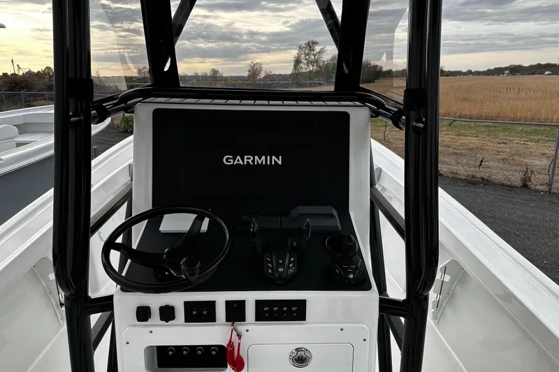 Slide: The Image of 2024 Pair Customs 24DV boat dashboard with Garmin navigation system, steering wheel, and controls. - 9