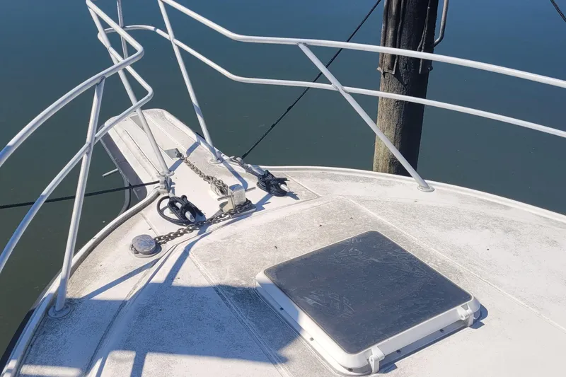 Slide: The Image of Bow of 1990 Phoenix 29 SFX Convertible boat with railing and anchor chain. - 11
