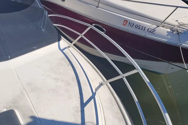 Slide: The Image of 1990 Phoenix 29 SFX Convertible boat docked, showing deck and railing details. - 14
