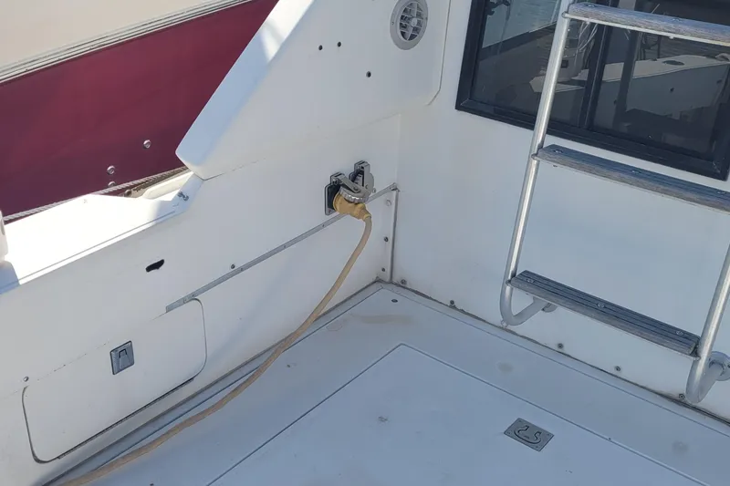 Slide: The Image of 1990 Phoenix 29 SFX Convertible boat deck with ladder and power connection. - 17