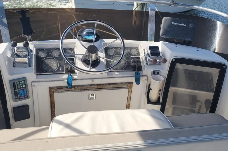 Slide: The Image of 1990 Phoenix 29 SFX Convertible boat dashboard with steering wheel and navigation instruments. - 20