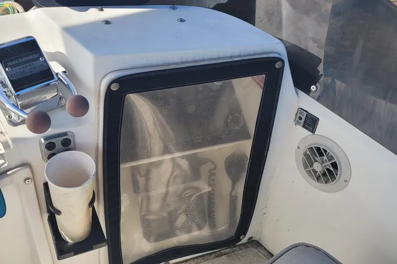 Slide: The Image of 1990 Phoenix 29 SFX Convertible boat dashboard with controls and cup holder. - 22