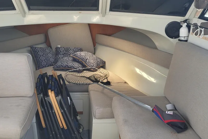 Slide: The Image of Interior of 1990 Phoenix 29 SFX Convertible with cushions, folding chairs, and fishing net. - 25