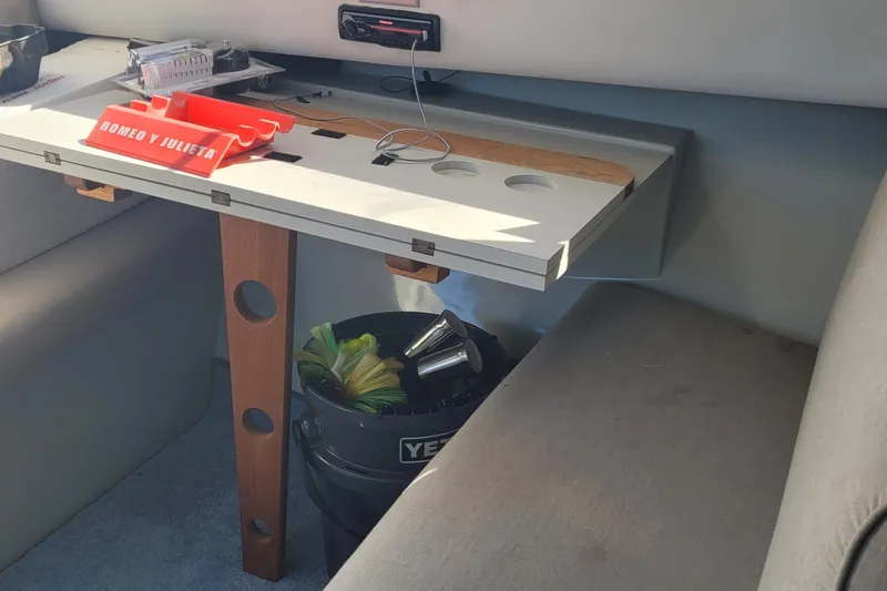 Slide: The Image of Interior of a 1990 Phoenix 29 SFX Convertible boat with table and seating area. - 27