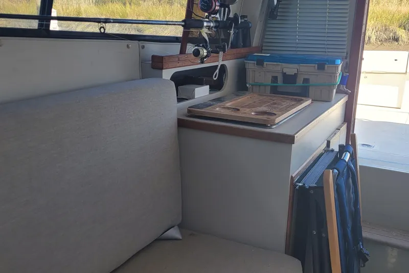 Slide: The Image of Interior of 1990 Phoenix 29 SFX Convertible boat with fishing gear and storage. - 29