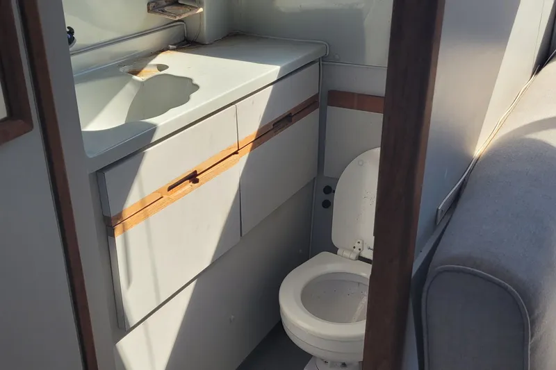 Slide: The Image of 1990 Phoenix 29 SFX Convertible boat bathroom with sink and toilet. - 30