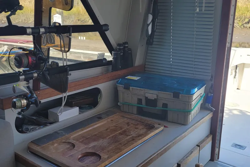 Slide: The Image of Interior of a 1990 Phoenix 29 SFX Convertible with fishing gear and tackle box. - 32