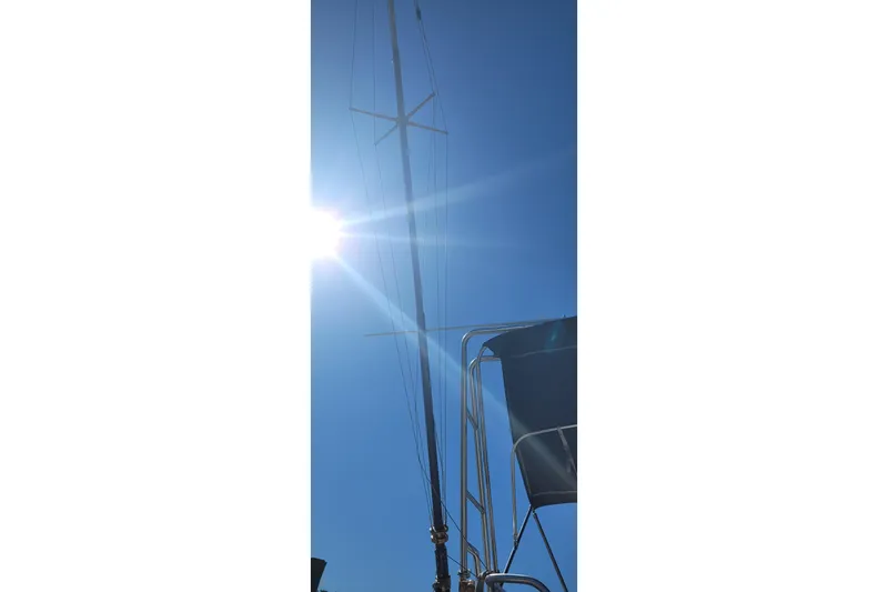 Slide: The Image of Mast of 1990 Phoenix 29 SFX Convertible boat against bright sun and clear blue sky. - 34