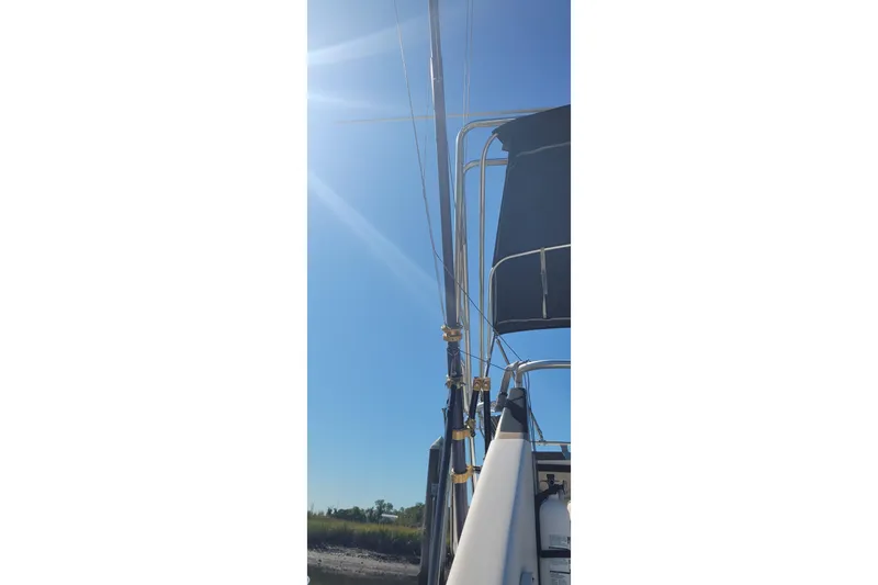 Slide: The Image of 1990 Phoenix 29 SFX Convertible boat under clear blue sky with sun flare. - 36