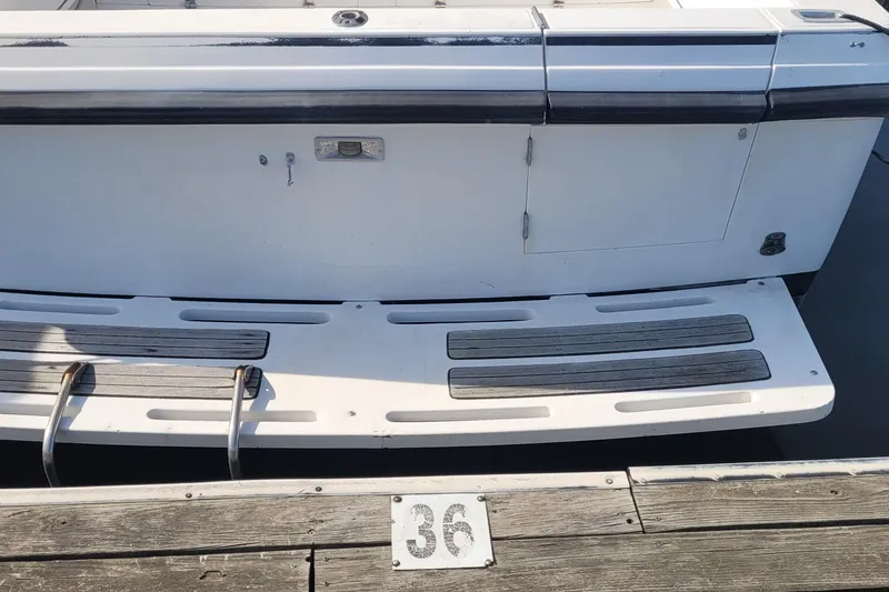 Slide: The Image of 1990 Phoenix 29 SFX Convertible boat stern with swim platform at dock number 36. - 6