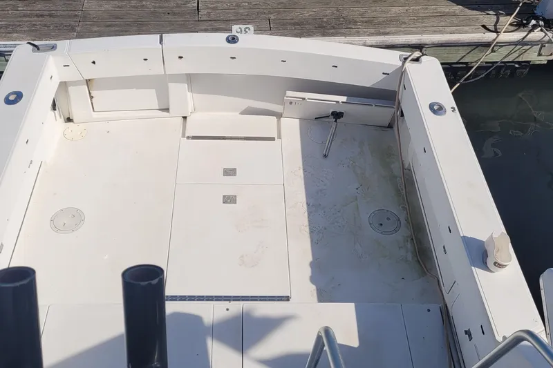 Slide: The Image of 1990 Phoenix 29 SFX Convertible boat deck, clean and spacious, docked at marina. - 9