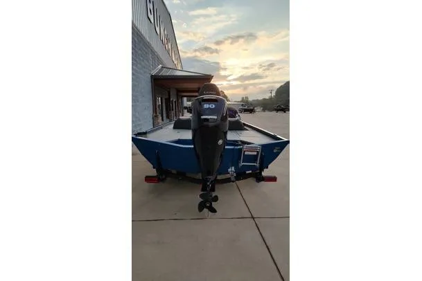 Slide: The Image of 2021 Lund 1775 Renegade boat with motor, parked outside a building at sunset. - 11