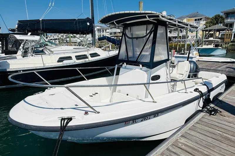 Slide: The Image of 2000 Boston Whaler 21 Outrage boat docked at marina under clear blue sky. - 10