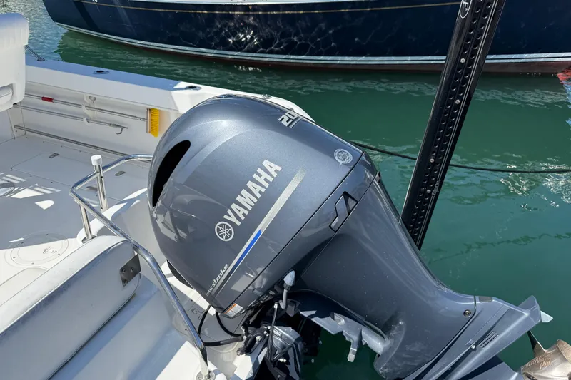 Slide: The Image of Boston Whaler 21 Outrage 2000 with Yamaha outboard motor, docked on calm water. - 5
