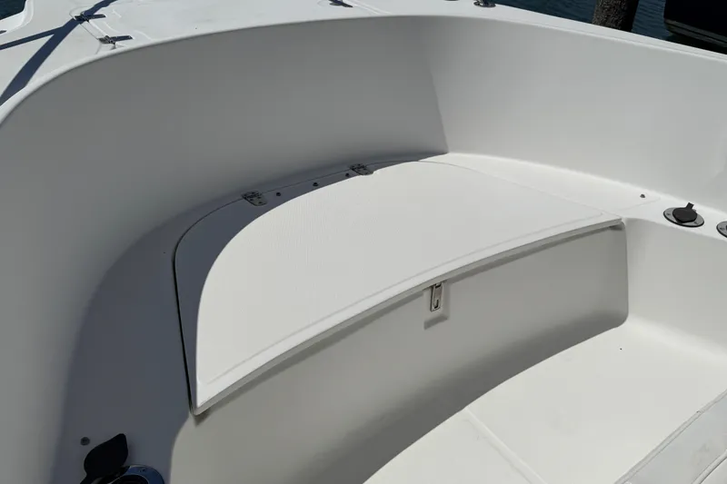 Slide: The Image of 2000 Boston Whaler 21 Outrage boat interior with white seating and storage compartment. - 9