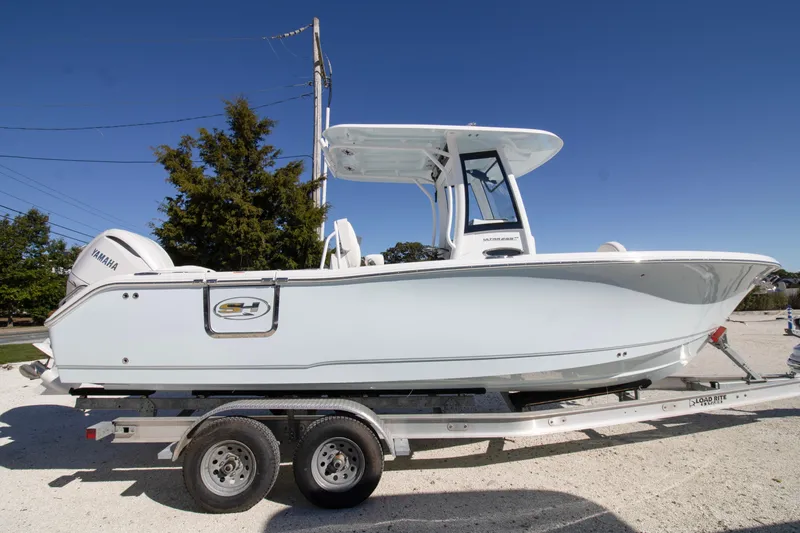 The Image of 2026 Sea Hunt Ultra 255 SE boat on trailer, side view, clear sky background. - 0