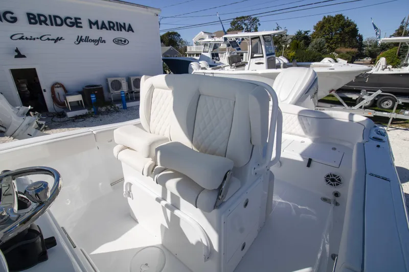 Slide: The Image of 2026 Sea Hunt Ultra 255 SE boat interior with white seating at a marina. - 6