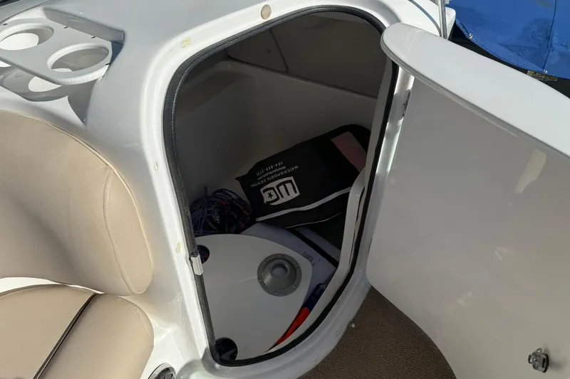 Slide: The Image of 2013 Hurricane Sundeck 217 IO boat storage compartment with beige seating and accessories. - 14