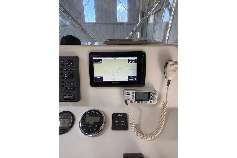 Slide: The Image of Edgewater 225CC 2001 boat dashboard with GPS, radio, and control panel. - 2