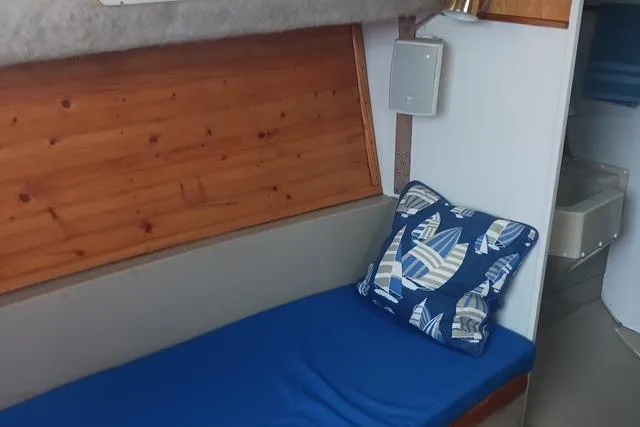 Slide: The Image of Interior of 1989 O'Day 272 sailboat with blue cushion and nautical-themed pillow. - 14