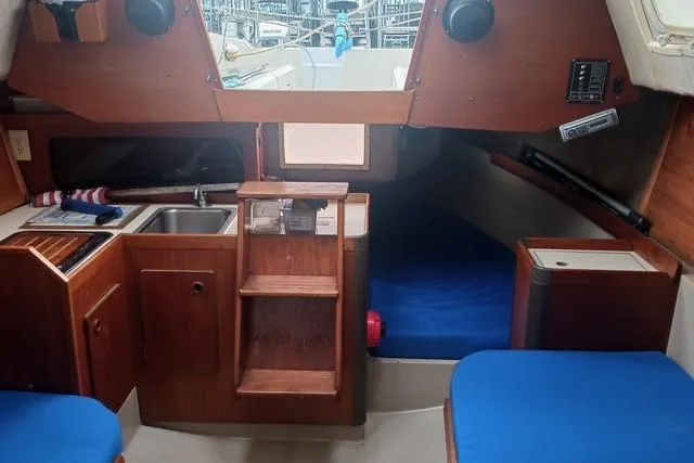 Slide: The Image of Interior of 1989 O'Day 272 sailboat with wooden cabinetry and blue cushions. - 15