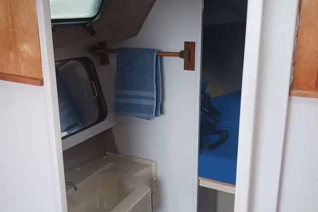 Slide: The Image of 1989 O'Day 272 sailboat interior with sink, towel, and cabin view. - 16