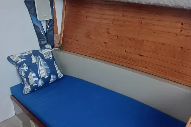 Slide: The Image of Interior of 1989 O'Day 272 sailboat with blue cushion and nautical-themed pillow. - 17