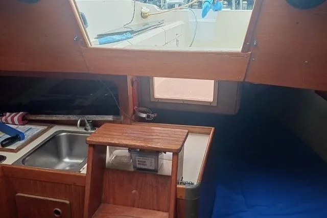 Slide: The Image of Interior of 1989 O'Day 272 sailboat with wooden cabinetry and compact kitchen area. - 18