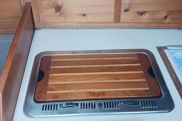 Slide: The Image of 1989 O'Day 272 sailboat interior with wooden countertop and built-in stove. - 19