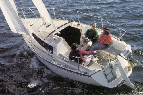 Slide: The Image of 1989 O'Day 272 sailboat with three people sailing on open water. - 21