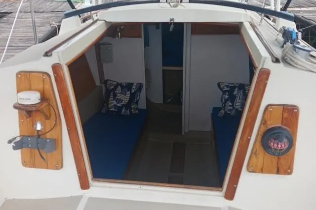 Slide: The Image of Interior view of a 1989 O'Day 272 sailboat with blue cushions and nautical decor. - 7