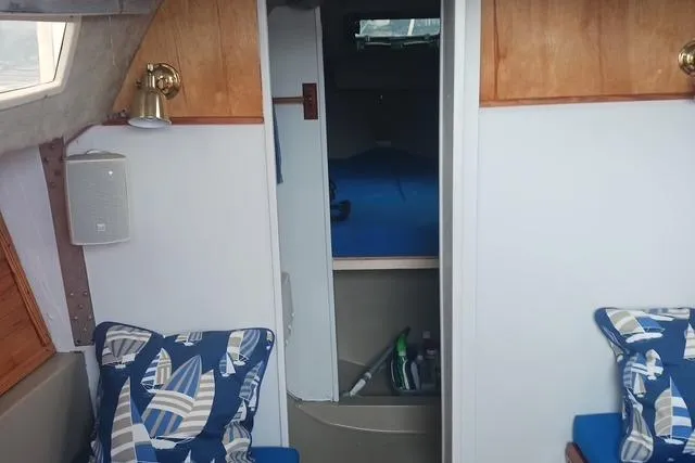 Slide: The Image of Interior of 1989 O'Day 272 sailboat with nautical-themed cushions and cozy cabin space. - 8