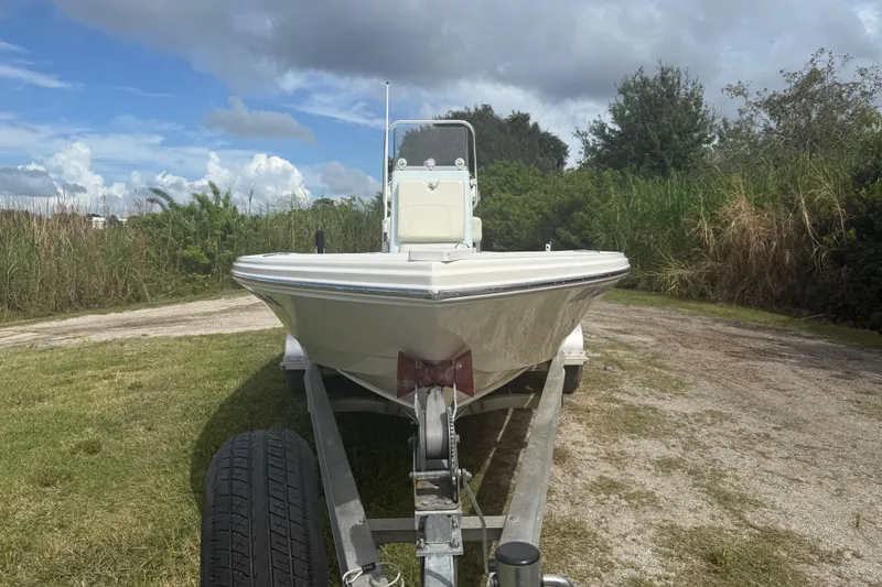 Slide: The Image of 2016 Pathfinder 2300 HPS boat on trailer, parked on grassy area under cloudy sky. - 10