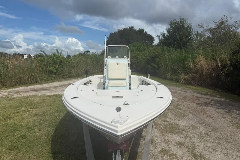 Slide: The Image of 2016 Pathfinder 2300 HPS boat on trailer, surrounded by greenery under a cloudy sky. - 11