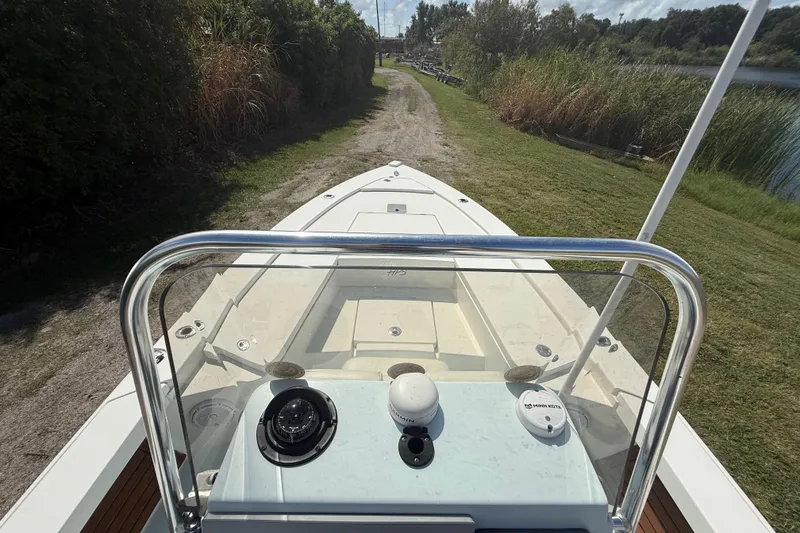 Slide: The Image of 2016 Pathfinder 2300 HPS boat on grassy path near water, viewed from helm. - 16