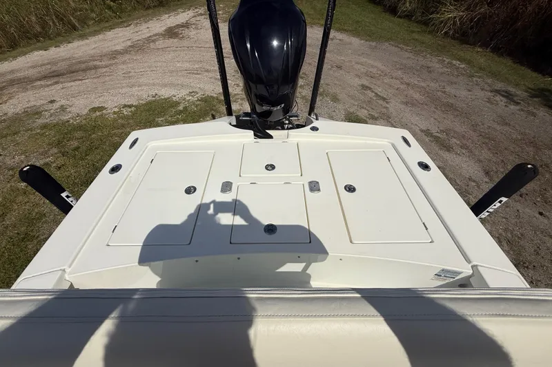 Slide: The Image of 2016 Pathfinder 2300 HPS boat deck with motor, parked on grassy terrain. - 24