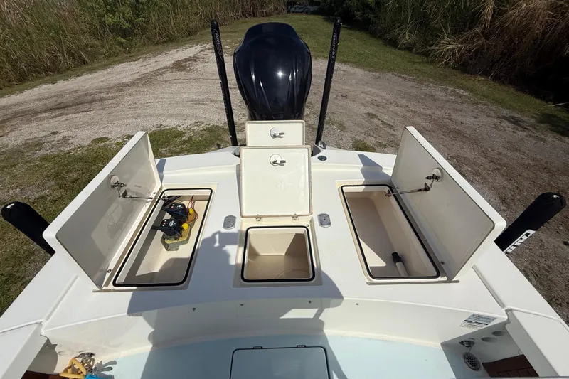 Slide: The Image of 2016 Pathfinder 2300 HPS boat with open storage compartments and visible engine. - 25
