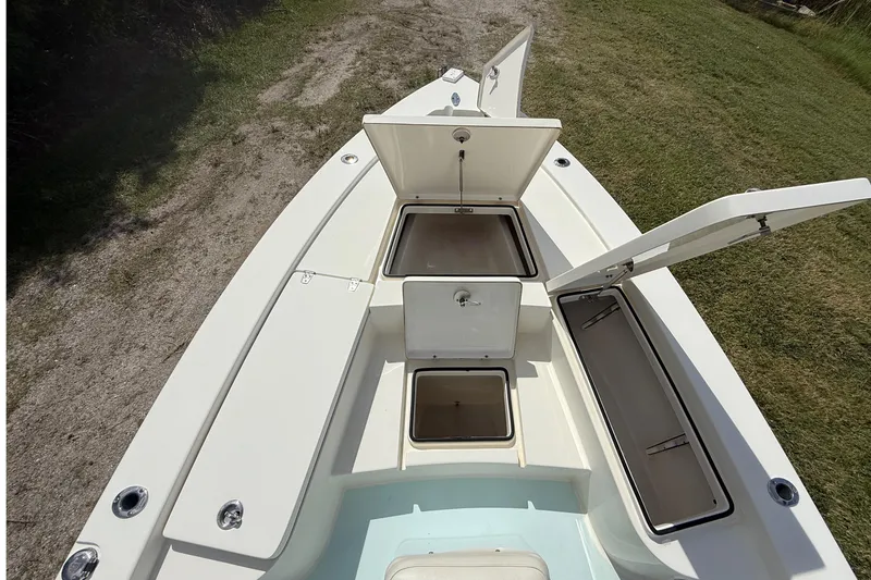 Slide: The Image of 2016 Pathfinder 2300 HPS boat with open storage compartments on grassy terrain. - 28