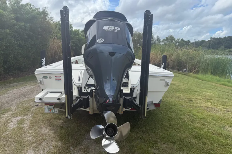 Slide: The Image of 2016 Pathfinder 2300 HPS boat with powerful outboard motor, parked on grassy area. - 3