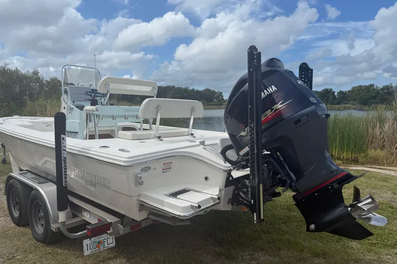 Slide: The Image of 2016 Pathfinder 2300 HPS boat with Yamaha engine on trailer by a lake. - 5