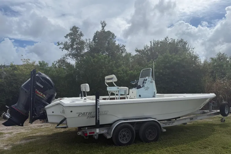 Slide: The Image of 2016 Pathfinder 2300 HPS boat on trailer, Yamaha engine, parked on grass, cloudy sky. - 7