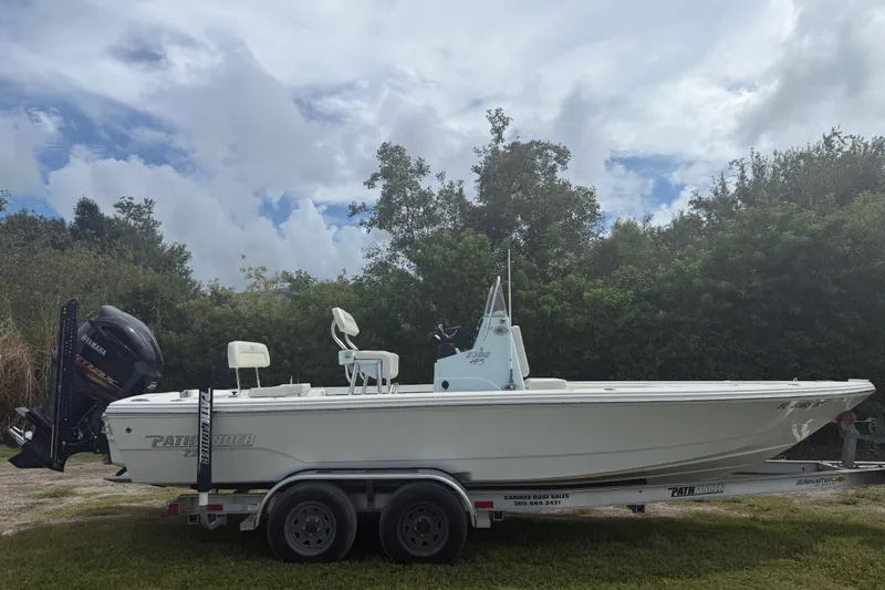 Slide: The Image of 2016 Pathfinder 2300 HPS boat on trailer, parked outdoors under cloudy sky. - 8