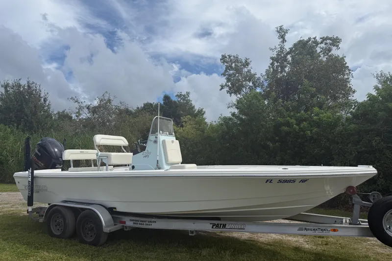 Slide: The Image of 2016 Pathfinder 2300 HPS boat on trailer, parked outdoors under cloudy sky. - 9