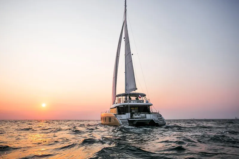 Slide: The Image of Sunreef 50 catamaran sailing at sunset, 2026 model, on open sea. - 4