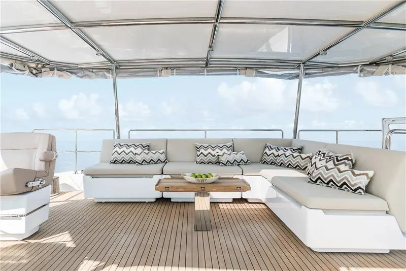 Slide: The Image of Luxurious Sunreef 50 yacht deck with elegant seating, 2026 model, featuring stylish cushions and wooden table. - 6