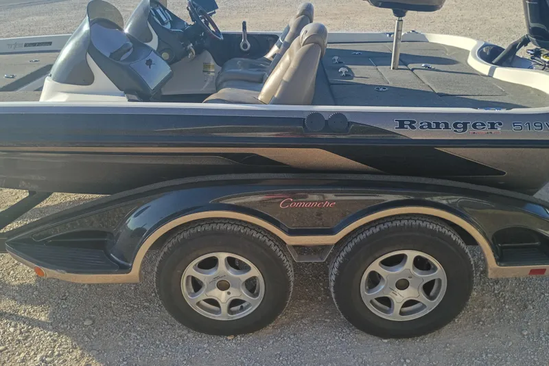 Slide: The Image of 2005 Ranger 519SVX Comanche boat with dual-axle trailer on gravel surface. - 13