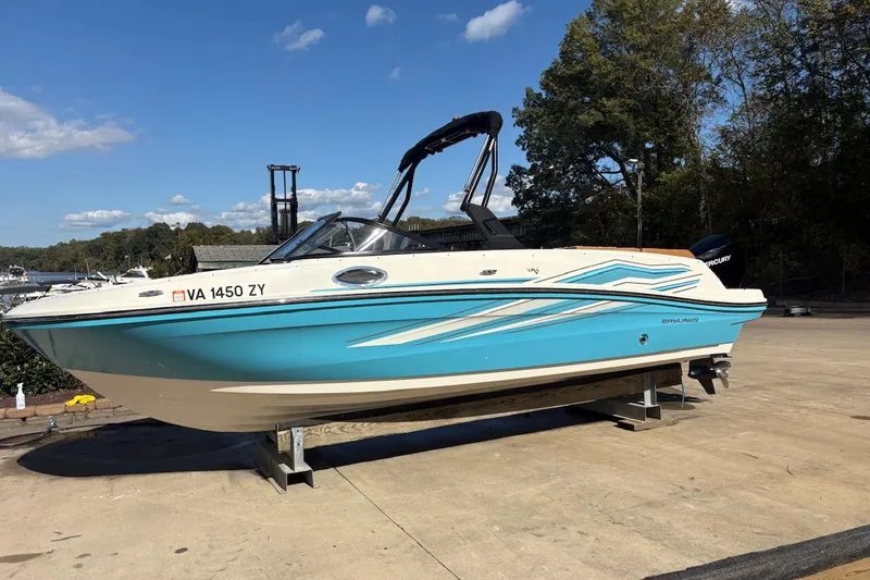 Slide: The Image of 2021 Bayliner VR6 Bowrider OB on a stand, blue and white design, outdoors. - 4