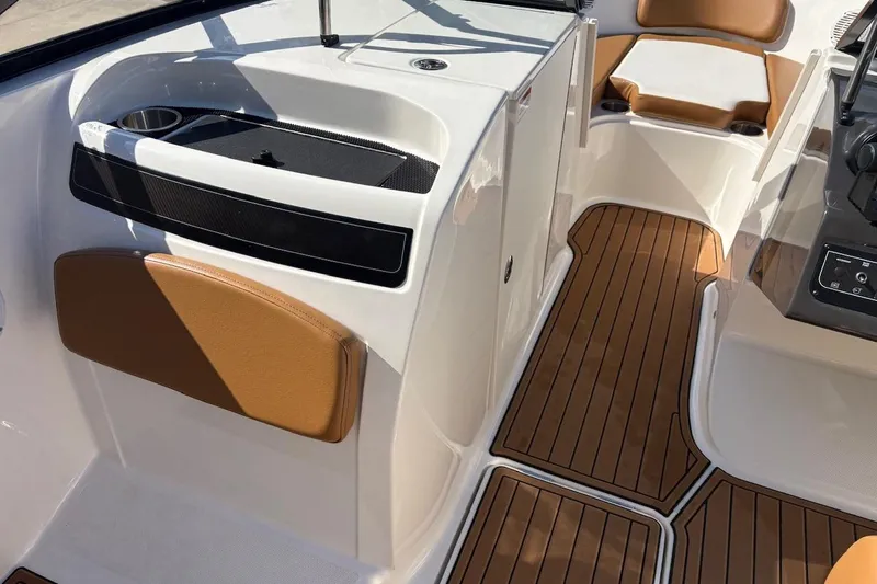Slide: The Image of 2021 Bayliner VR6 Bowrider OB interior with brown seating and wood-style flooring. - 9